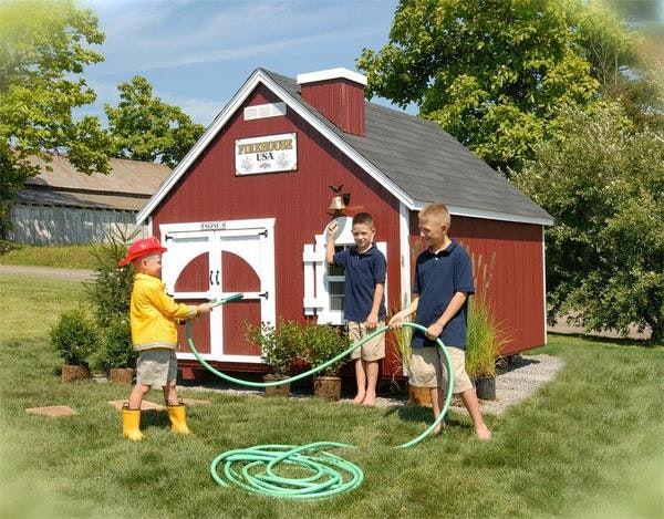 Amish kids firehouse playhouse with engine doors, firebell, and red siding panels.
